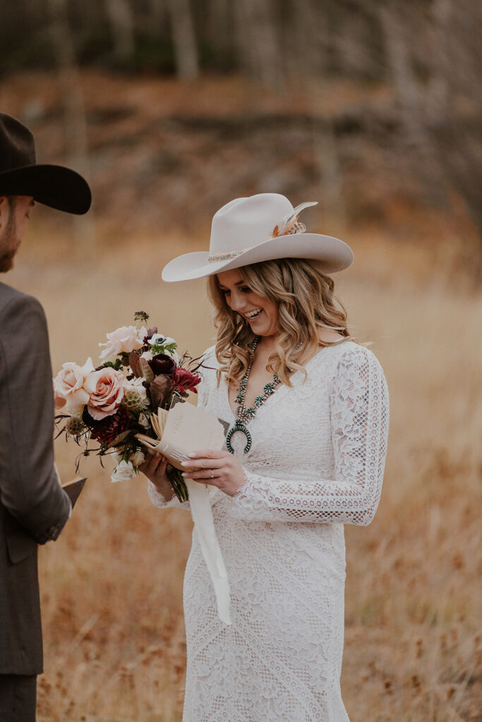 Bride laughing while reading her vows