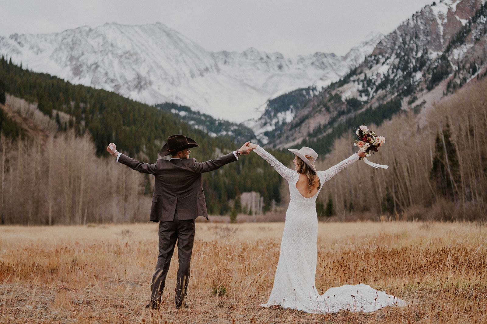 Bride and groom celebrating with their hands in the air during their Aspen, Colorado elopement