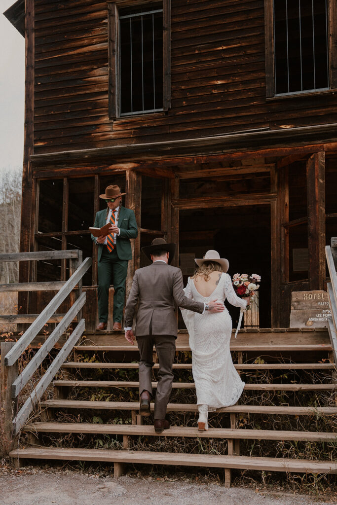 Bride and groom walking up the steps for their Ashcroft Ghost town elopement ceremony in Aspen, Colorado