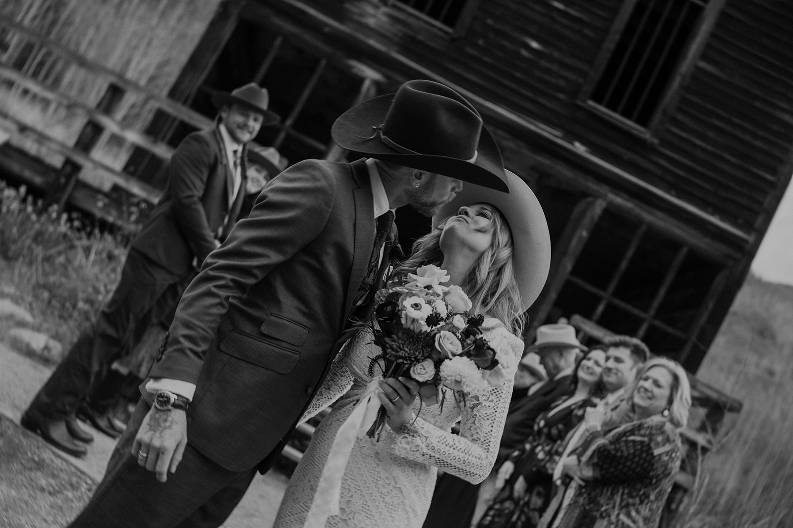 Black and white photo of a bride and groom going in for a kiss after their intimate Ashcroft Ghost town elopement ceremony in Aspen, Colorado