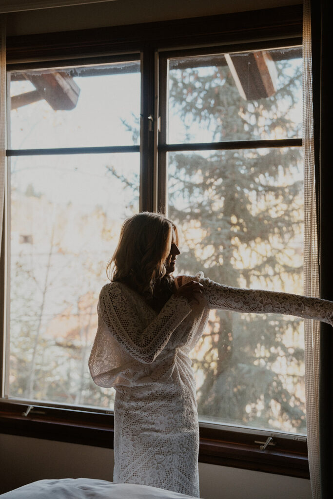 Bride putting her dress on for her Aspen, Colorado elopement