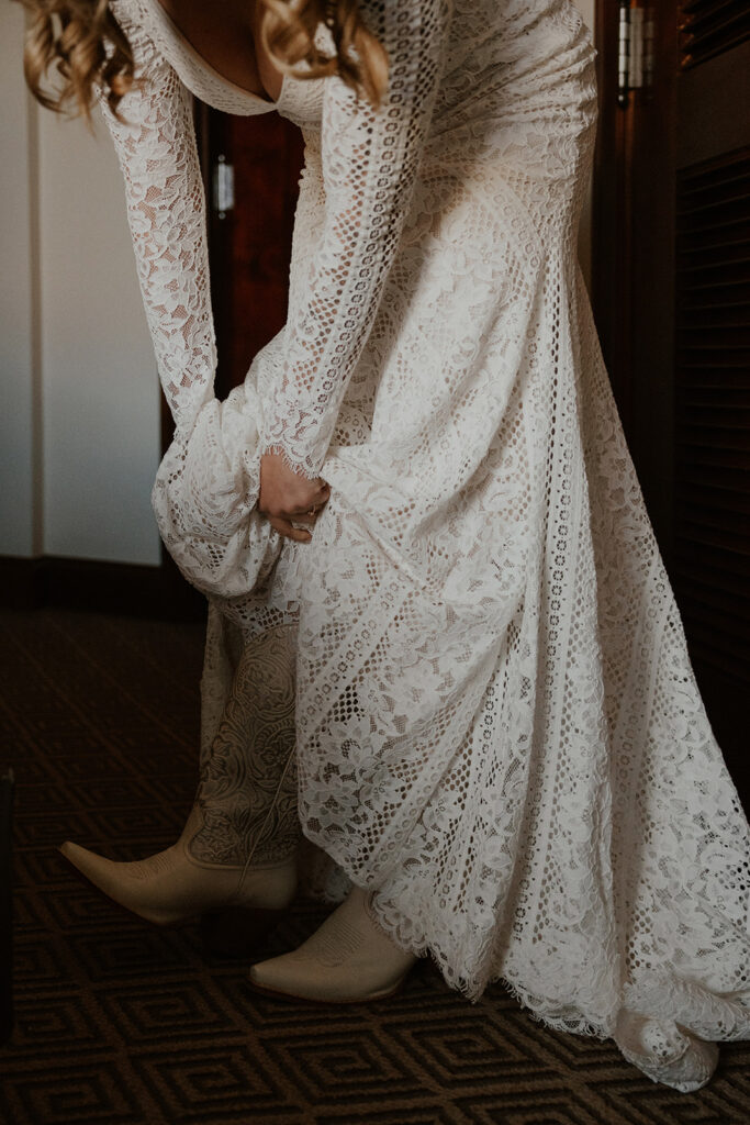 Bride putting her cowgirl boots on for her Aspen, Colorado elopement