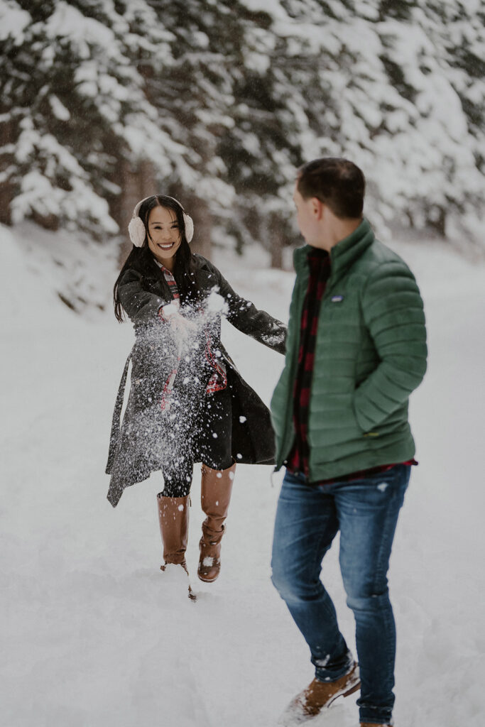 Woman throwing a snowball at her fiancé during their Boreas Pass engagement