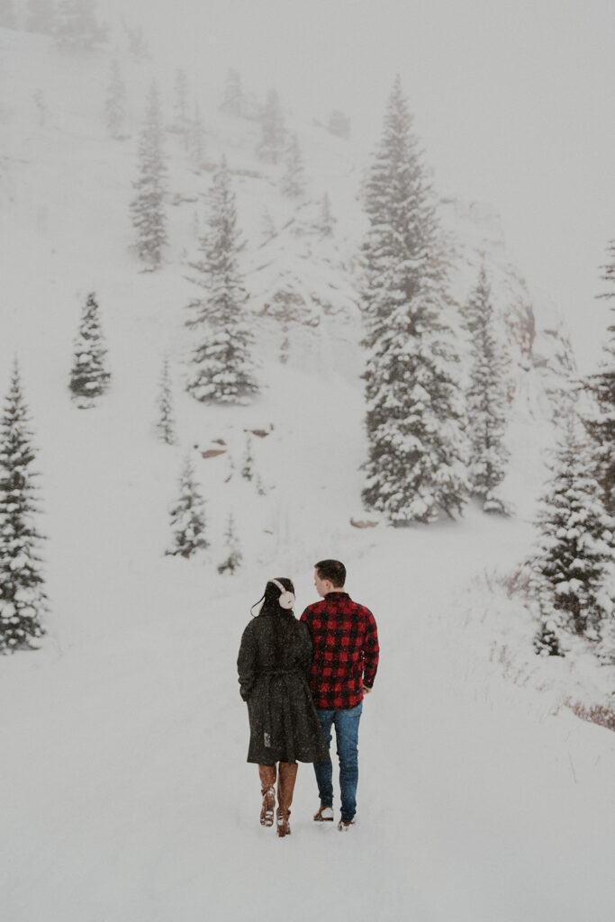 Couple walking in Boreas Pass for their winter Colorado photoshoot