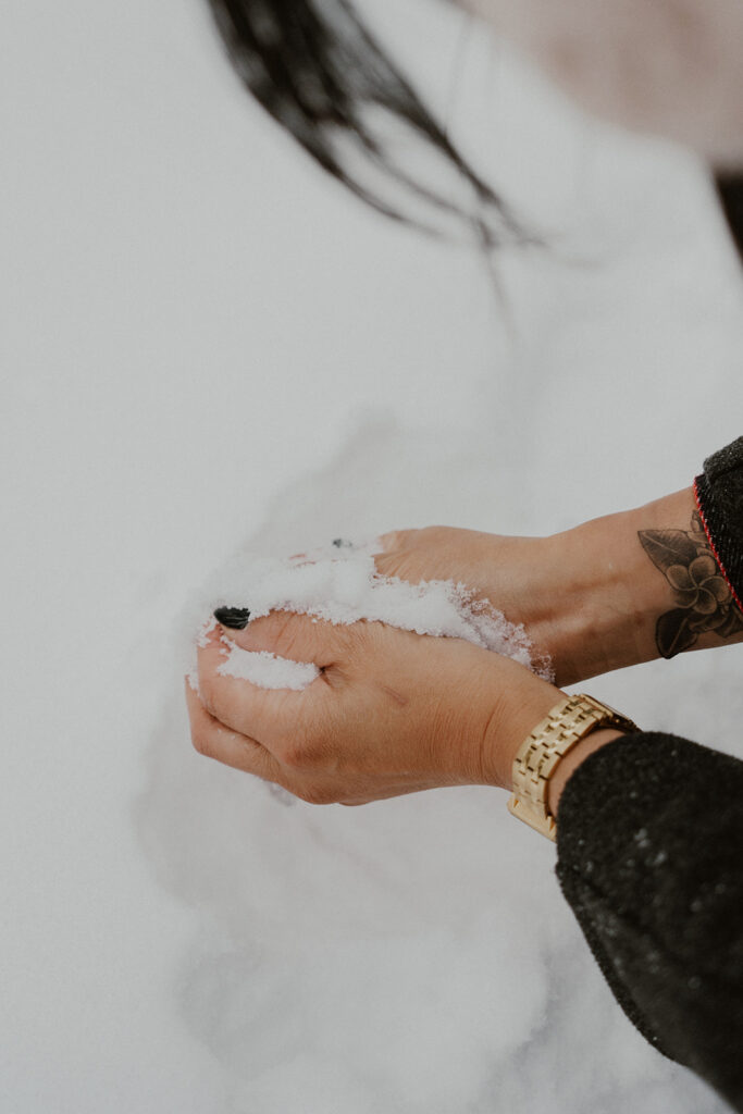 Woman making a snowball during her Boreas Pass engagement